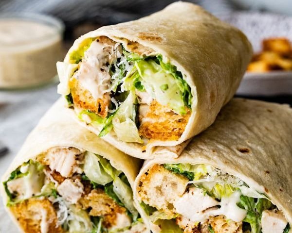 Chicken Caesar Wrap 3 Chicken Caesar wrap halves showing chicken, romaine and creamy dressing
