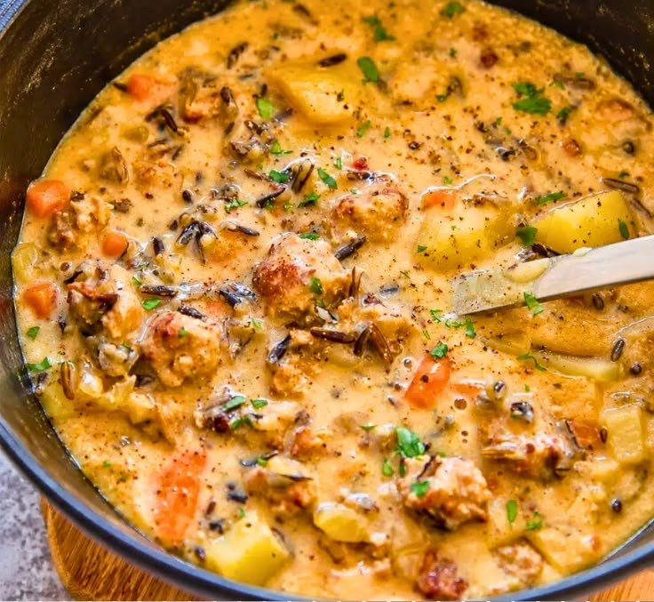 Close overhead shot of creamy sausage potato chowder with potatoes, carrots and sausage crumbles