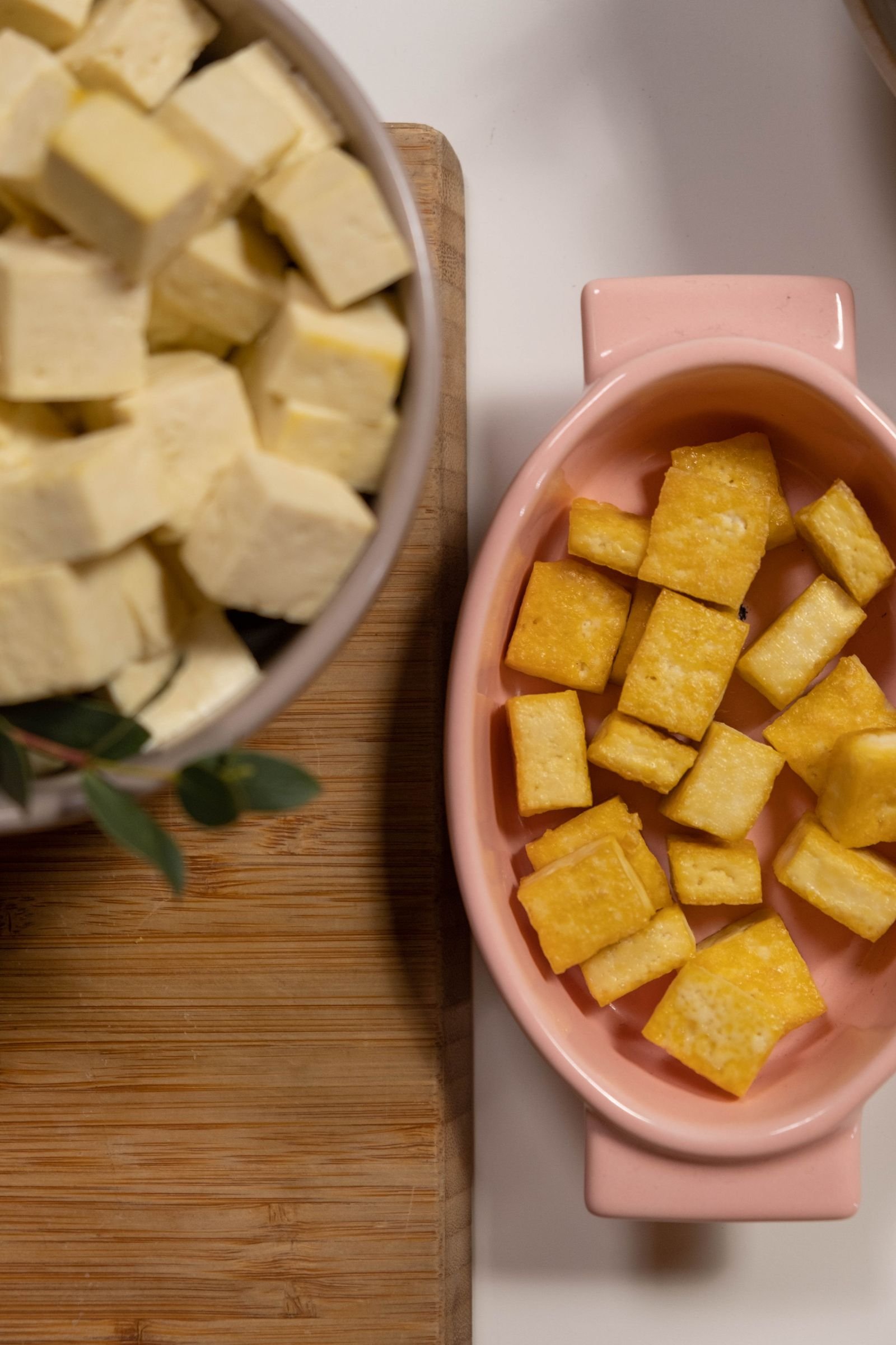 Crispy Tofu Bowls (Golden Tofu, Crunchy Veggies, Spicy Mayo) 3 Golden fried tofu cubes beside raw tofu cubes in a pink dish