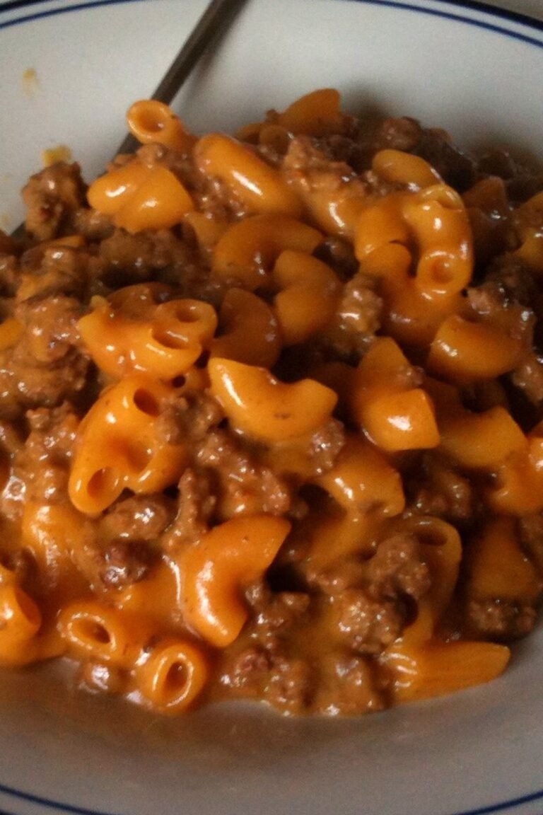 A bowl of creamy crockpot hamburger helper with cheesy elbow pasta and seasoned ground beef, ready to serve for dinner.
