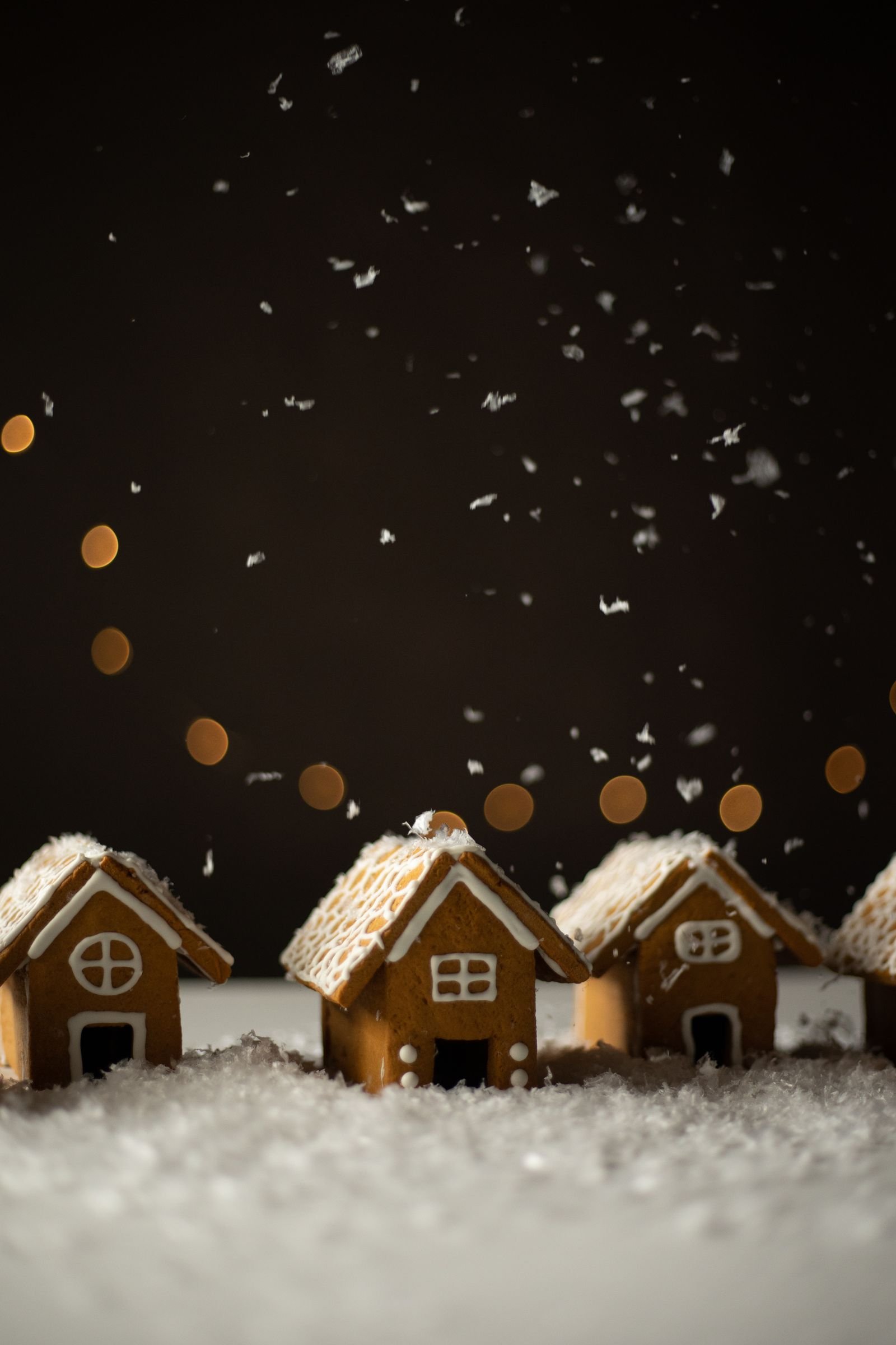 Gingerbread House (Sturdy Walls, Thick Icing, Candy-Covered for Christmas) 3 Small frosted gingerbread houses in snow with warm lights