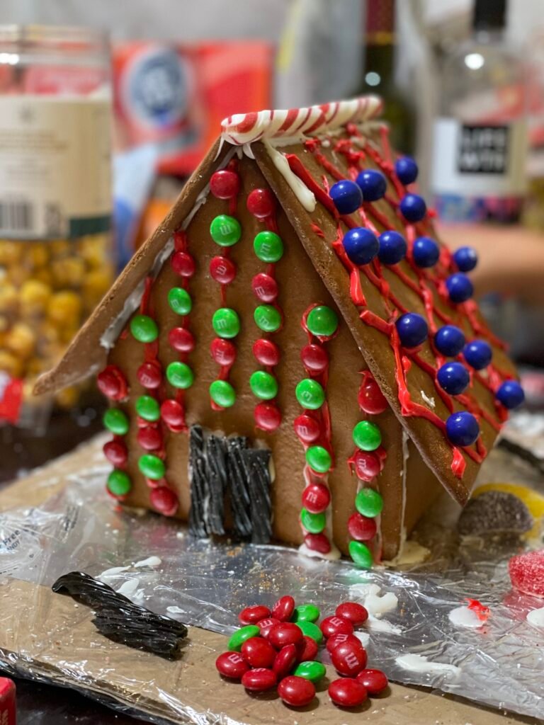 A candy-decorated gingerbread house with red, green, and blue candies