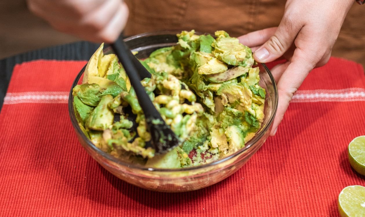 Mashing avocados for spiderweb guacamole