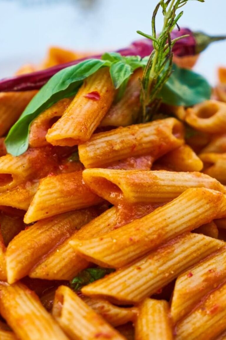 Creamy tomato herb pasta with roasted cherry tomatoes and soft white cheese in a bowl