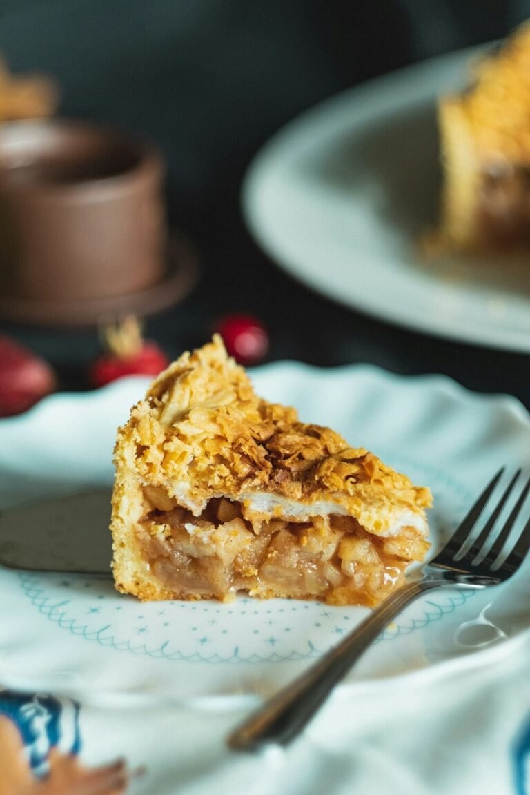 Slice of apple crisp with golden oat crumble topping and tender cinnamon apple filling