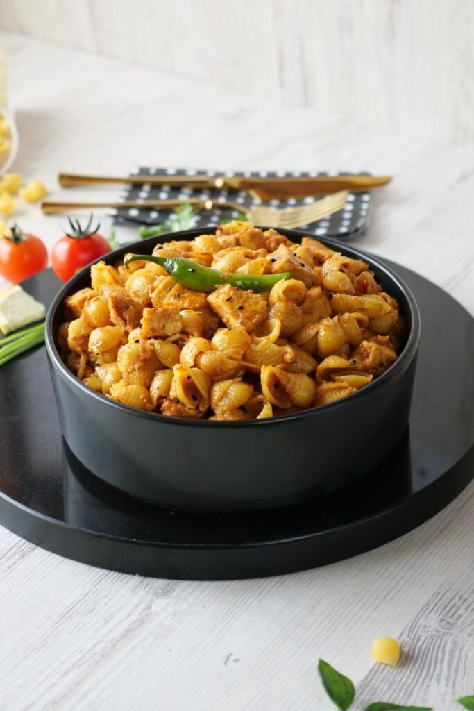 Creamy butter chicken pasta in a black bowl