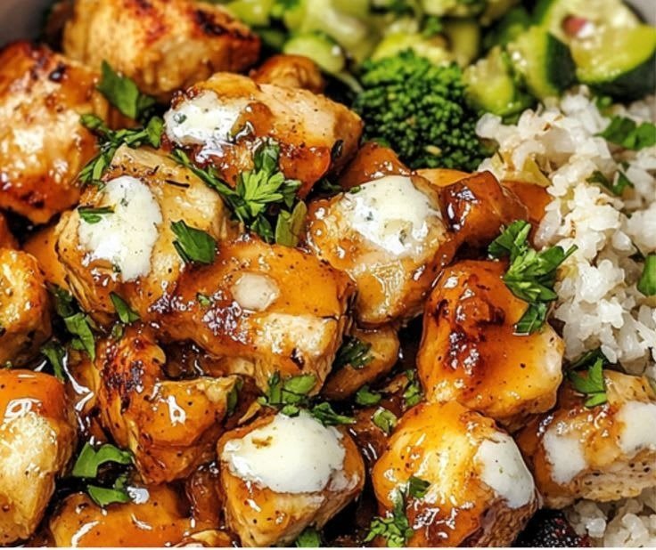 Close-up of hot honey chicken bites with herbs and a creamy drizzle