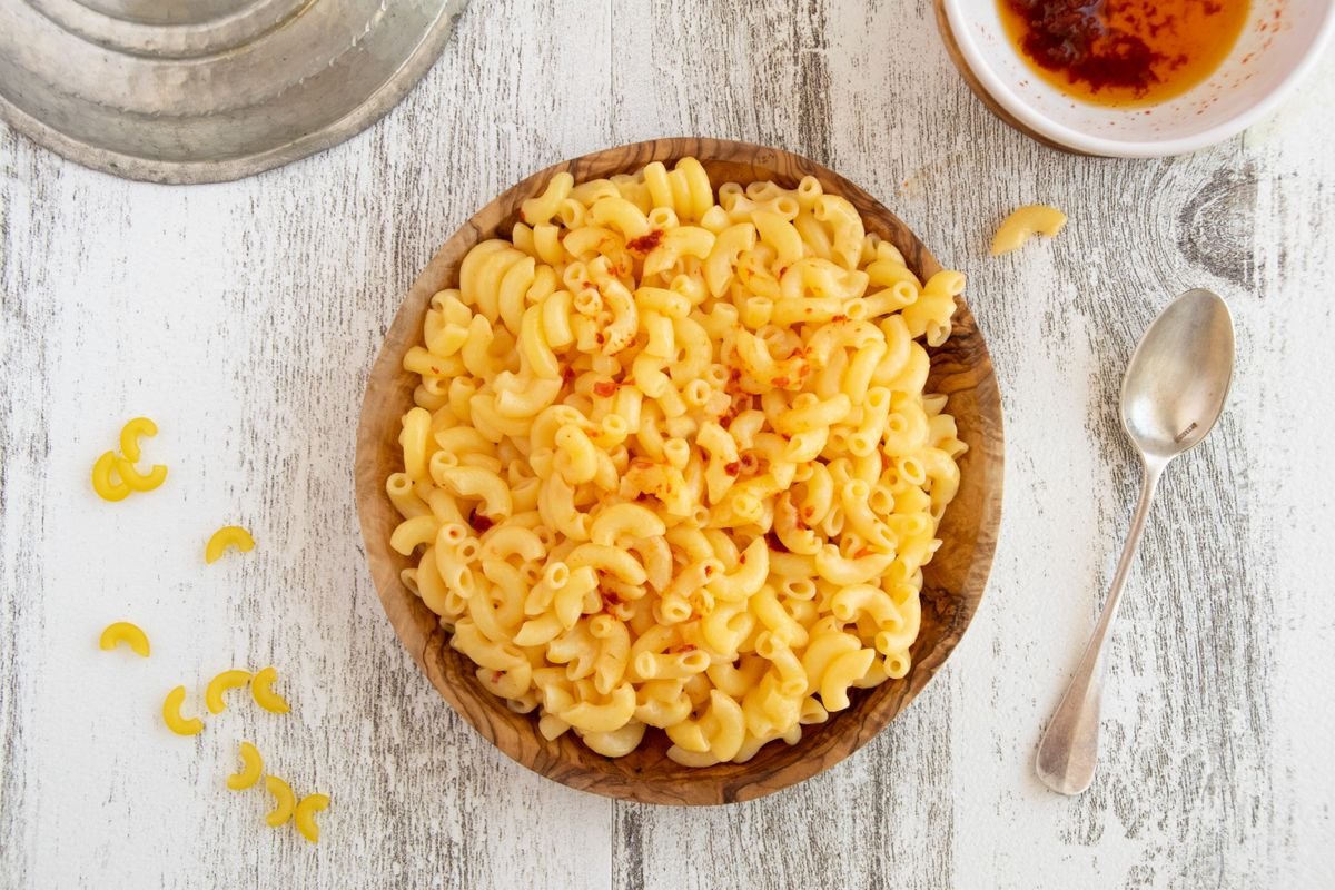 Folding macaroni into the pumpkin cheese sauce