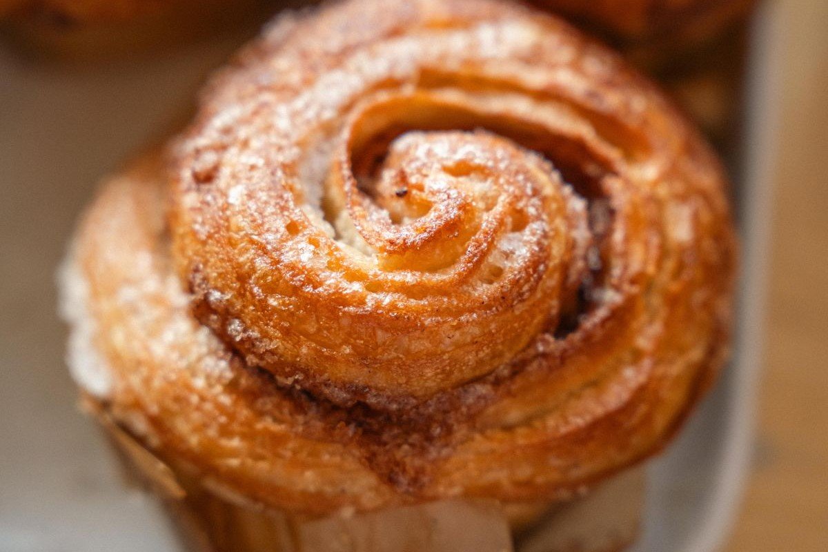 Soft & Fluffy Cinnamon Rolls (The 2-Hour Bakery-Style Recipe) 3 Close-up of a single golden cinnamon roll dusted with sugar