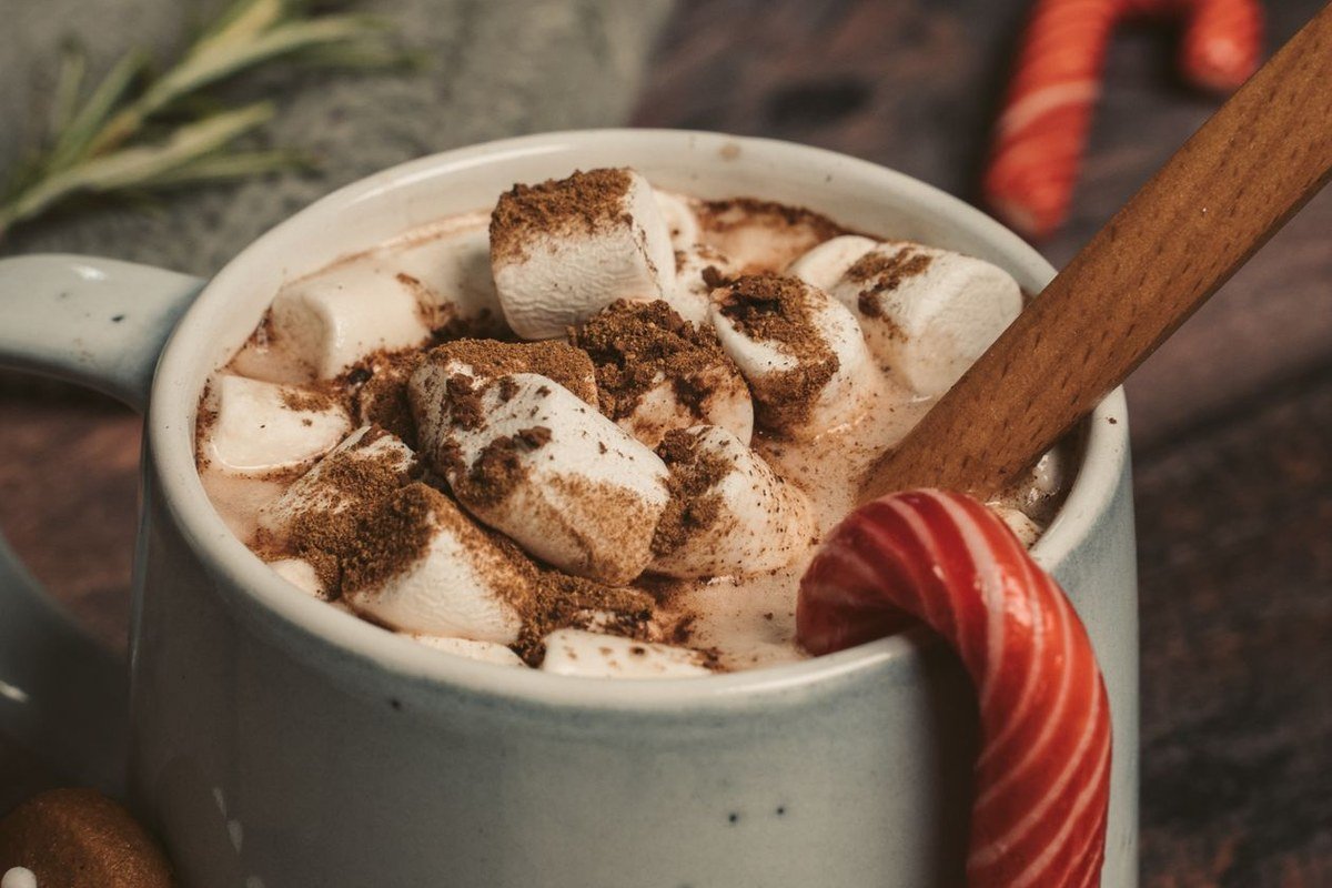 Slow Cooker Pumpkin Hot Chocolate (The Creamy Set-It-and-Forget-It Fall Drink) 4 Hot chocolate with marshmallows dusted with cocoa and a candy cane stirrer