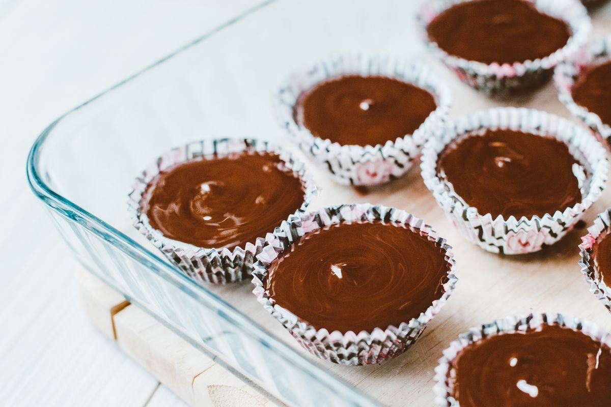 Death by Chocolate Cupcakes (The Ultra-Fudgy 40-Minute Triple-Chocolate Recipe) 4 Chocolate cupcakes with glossy ganache tops arranged in a glass baking dish