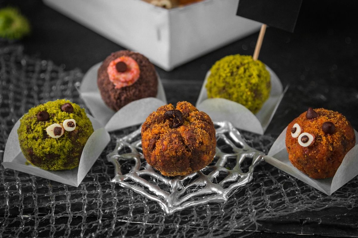Spooky Eyeball Oreo Cookie Balls (The No-Bake 20-Minute Halloween Treat) 4 Monster eyeball cookie balls arranged on a spiderweb tray with Halloween decorations