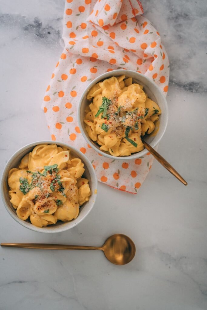 Creamy Pumpkin Pasta (The Cozy 25-Minute Fall Pasta) 5 Two bowls of golden creamy pumpkin pasta on a marble table