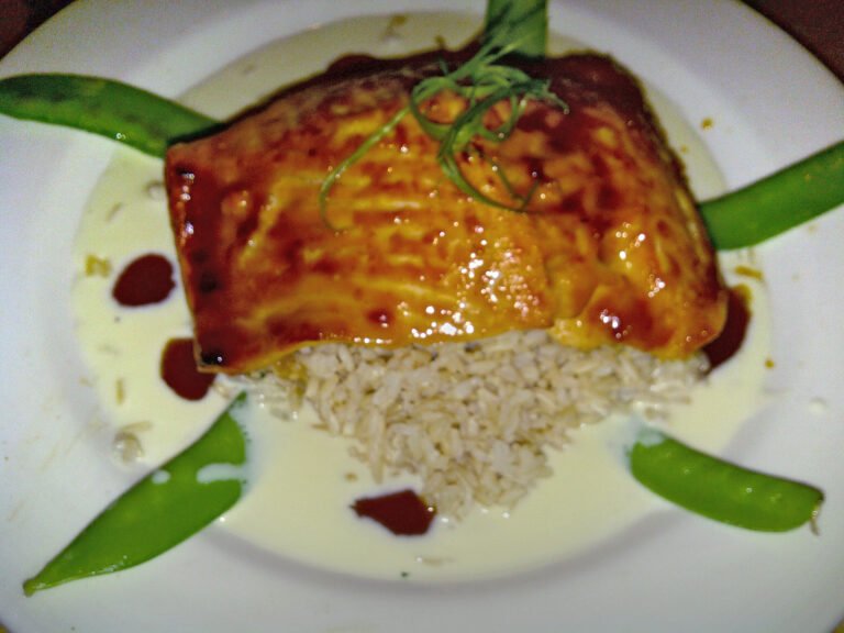 Glazed miso butter salmon fillet over rice with green onion garnish