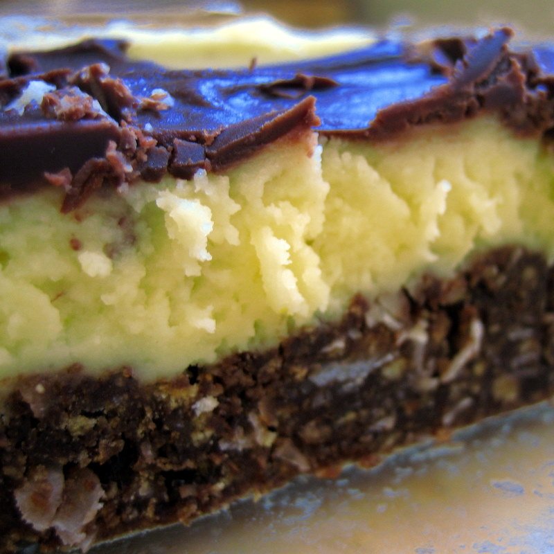 Close-up detail of a Nanaimo bar showing the chocolate crumb base, custard layer and chocolate top