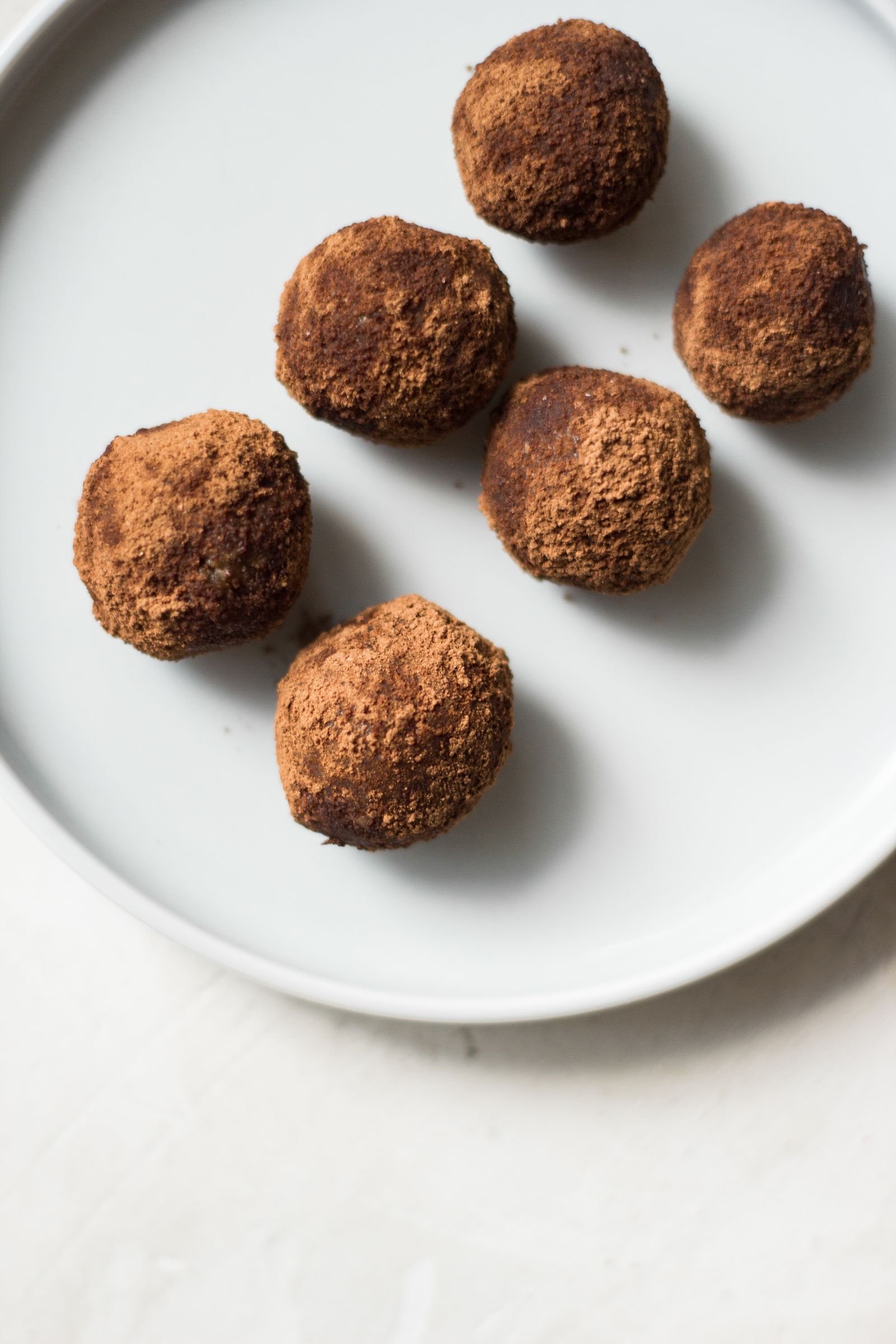 Oreo Balls (3-Ingredient No-Bake Chocolate Truffles) 3 Cocoa-dusted chocolate truffle balls arranged on a white plate