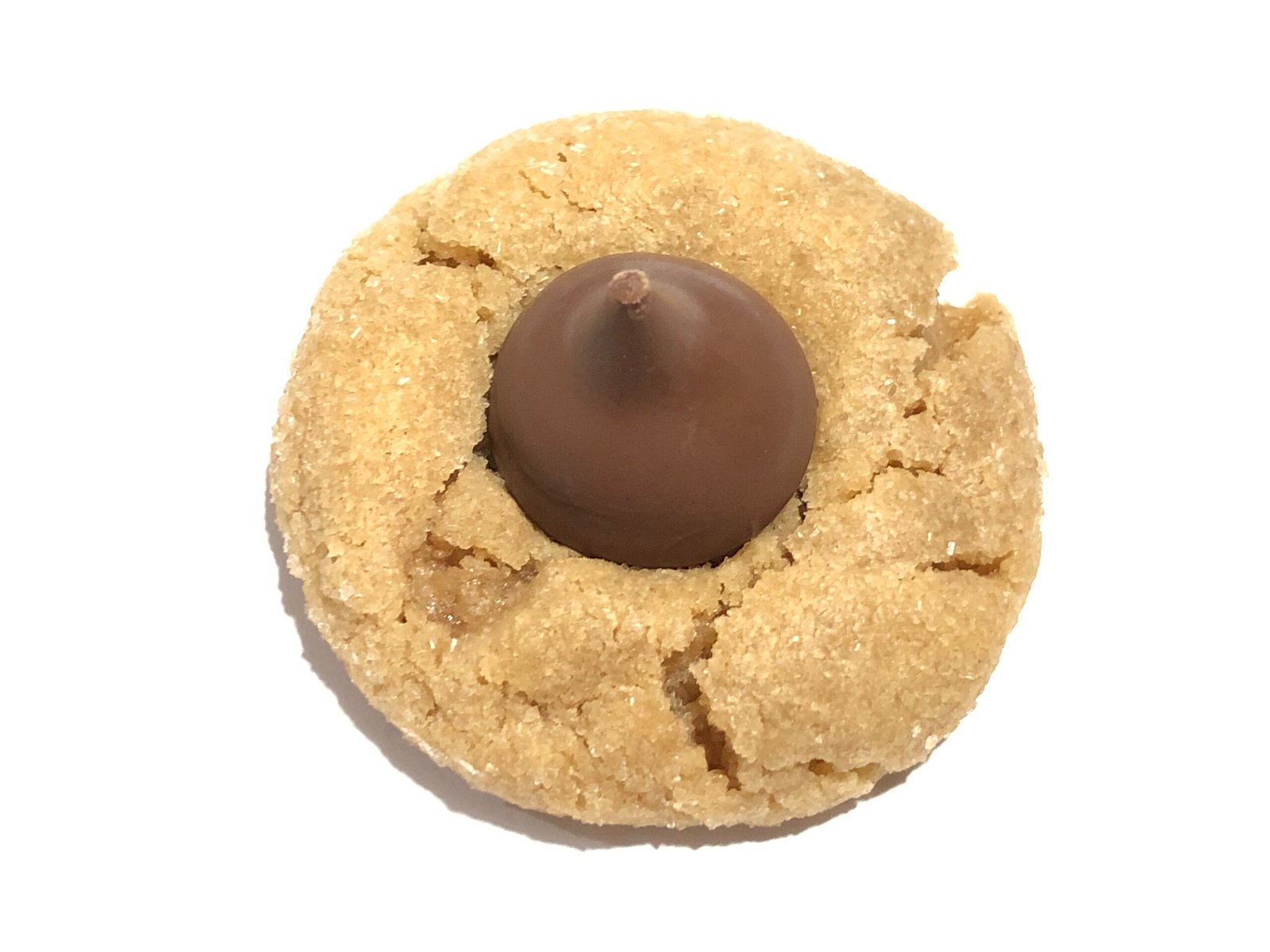 A plate of soft peanut butter blossom cookies rolled in sugar, each topped with a chocolate kiss pressed into the center of the cookie.