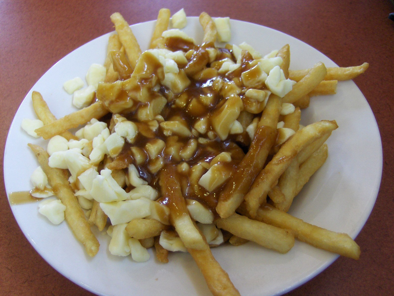 Classic poutine: crispy golden fries topped with white cheese curds and glossy brown gravy