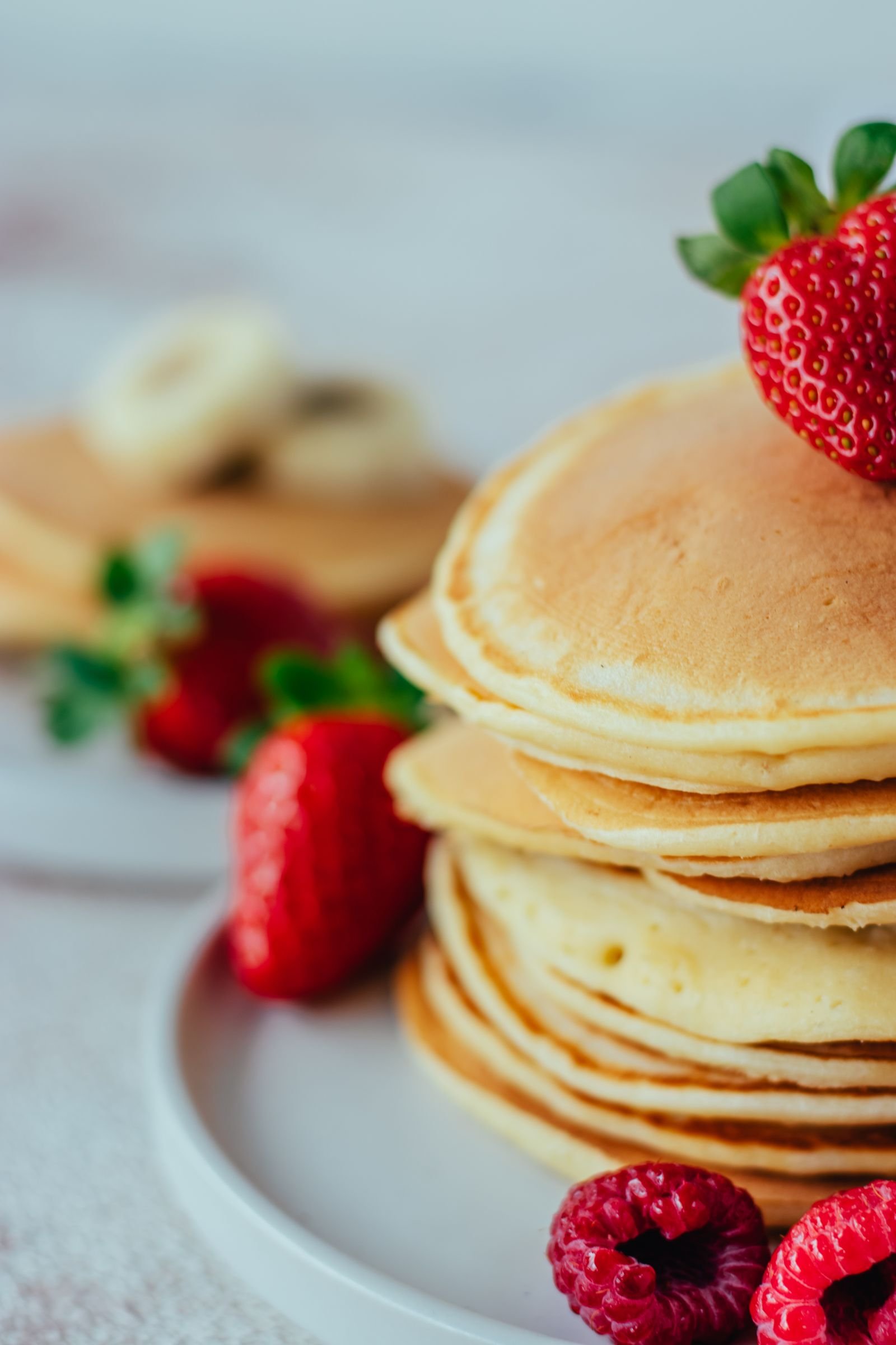 Protein Pancakes (Thick, Fluffy, and Seriously Filling) 2 Stack of thick, golden protein pancakes topped with strawberries and raspberries