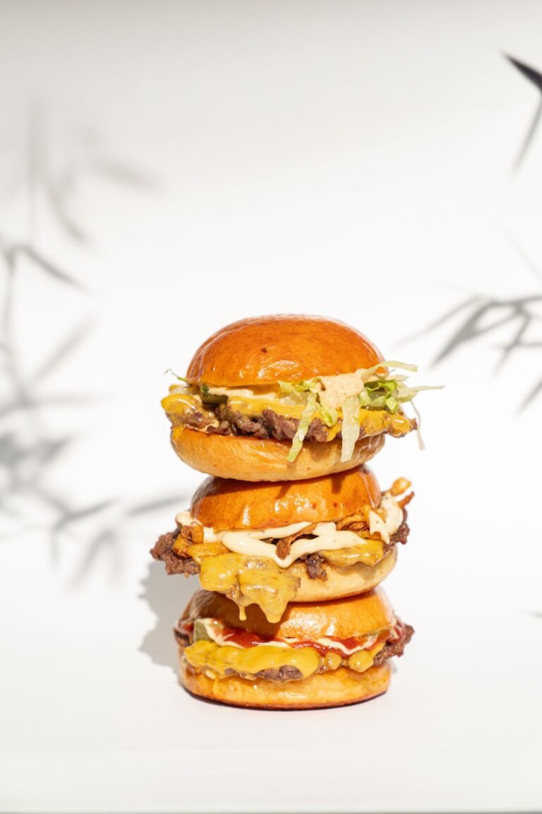 Two smash burgers with crispy-edged beef patties, melted cheese, pickles, and creamy secret sauce in toasted buns on a plate