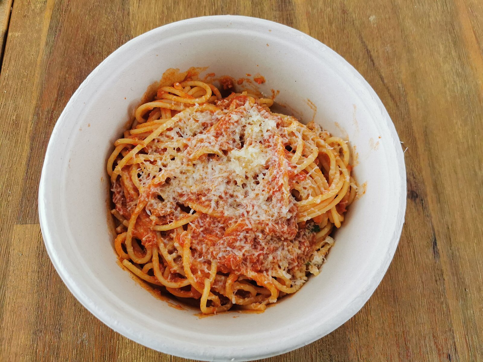 Spaghetti Bolognese (Rich, Slow-Simmered Meat Sauce) 2 A white bowl of spaghetti bolognese topped with rich red meat sauce and a generous mound of grated Parmesan cheese on top